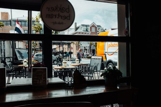 Telefoon in hand met zoekopdracht postnl klantenservice telefoonnummer 088 en PostNL-pakket op tafel