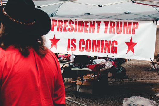Smartphone met live updates over trump nieuws vandaag en Amerikaanse politieke koppen op het scherm