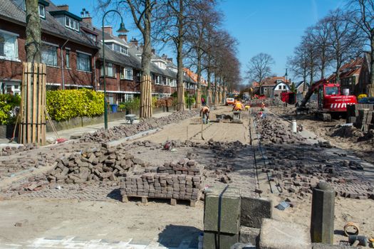 Sfeervolle landelijke tuin met grindpad, houten bank, bloeiende borders en gebakken klinkers