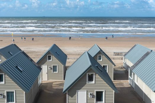 Laptop en telefoon met VakantieVeilingen-aanbiedingen, iemand vergelijkt biedingen en servicekosten